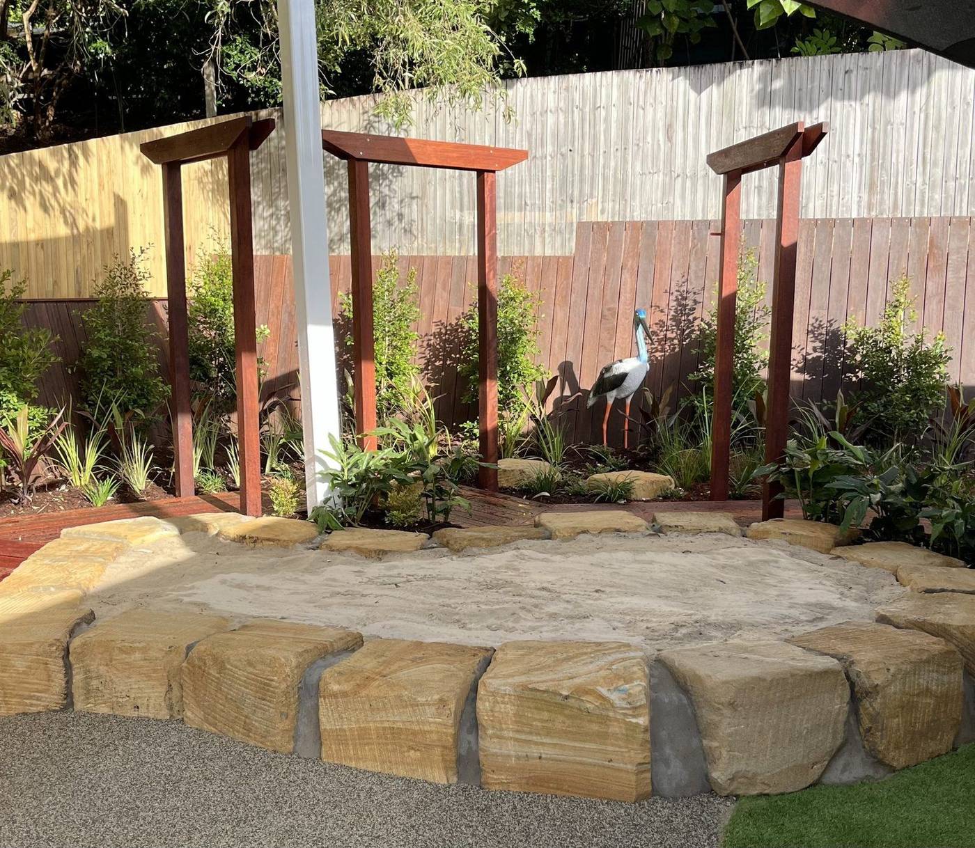 Natural timber playscape with synthetic turf and outdoor learning elements