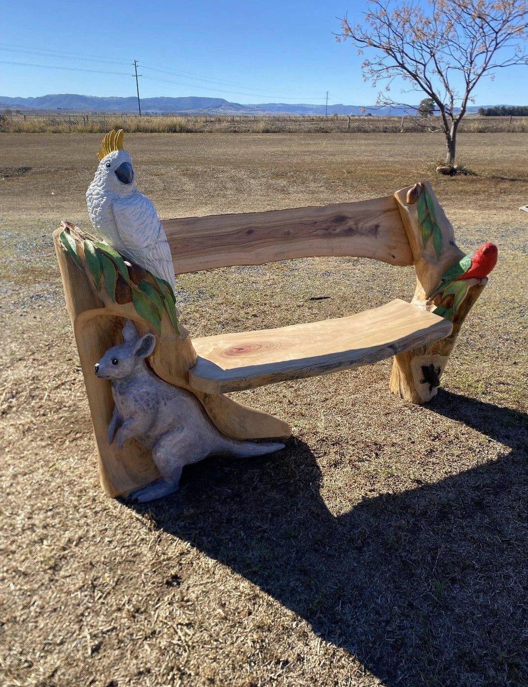 Carved timber bench with cockatoo, kangaroo and king parrot