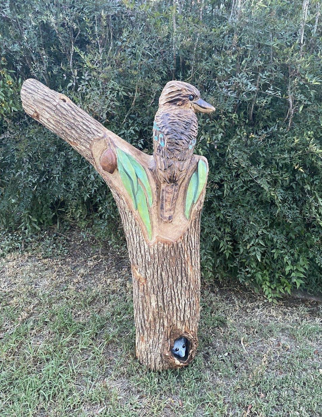 Hand-carved kookaburra and possum on a timber post