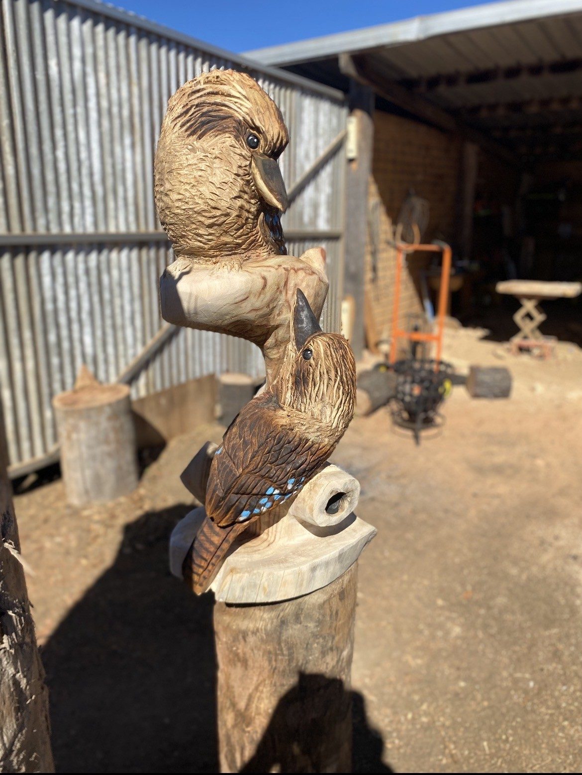 Two carved kookaburras on a timber post by Cossy's Chainsaw Artistry