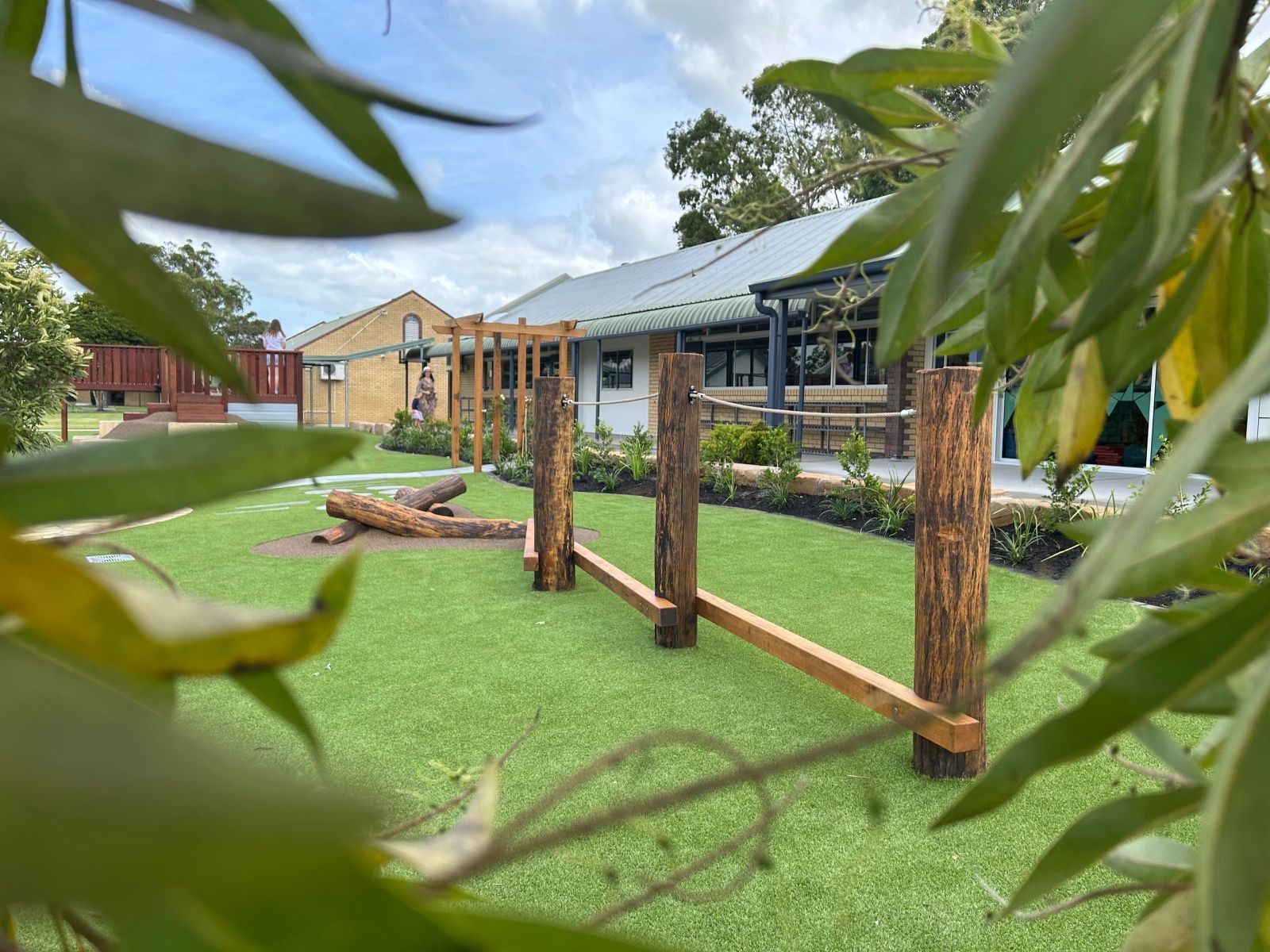 School nature play area with timber balance beam and native plantings