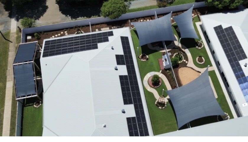 Aerial view of childcare centre with synthetic turf play areas, shade sails and landscaping