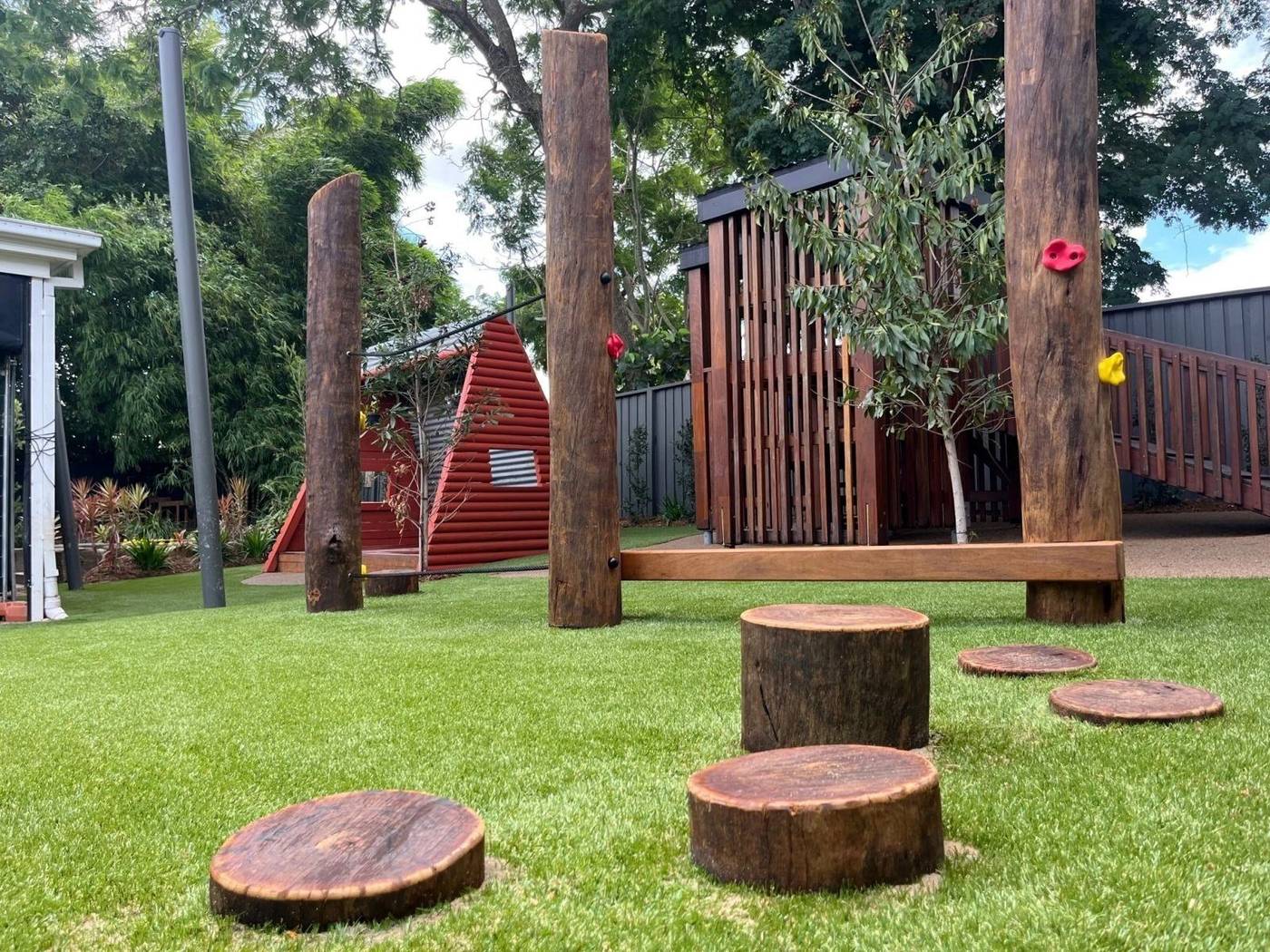 Log stepping discs and timber balance elements on synthetic turf