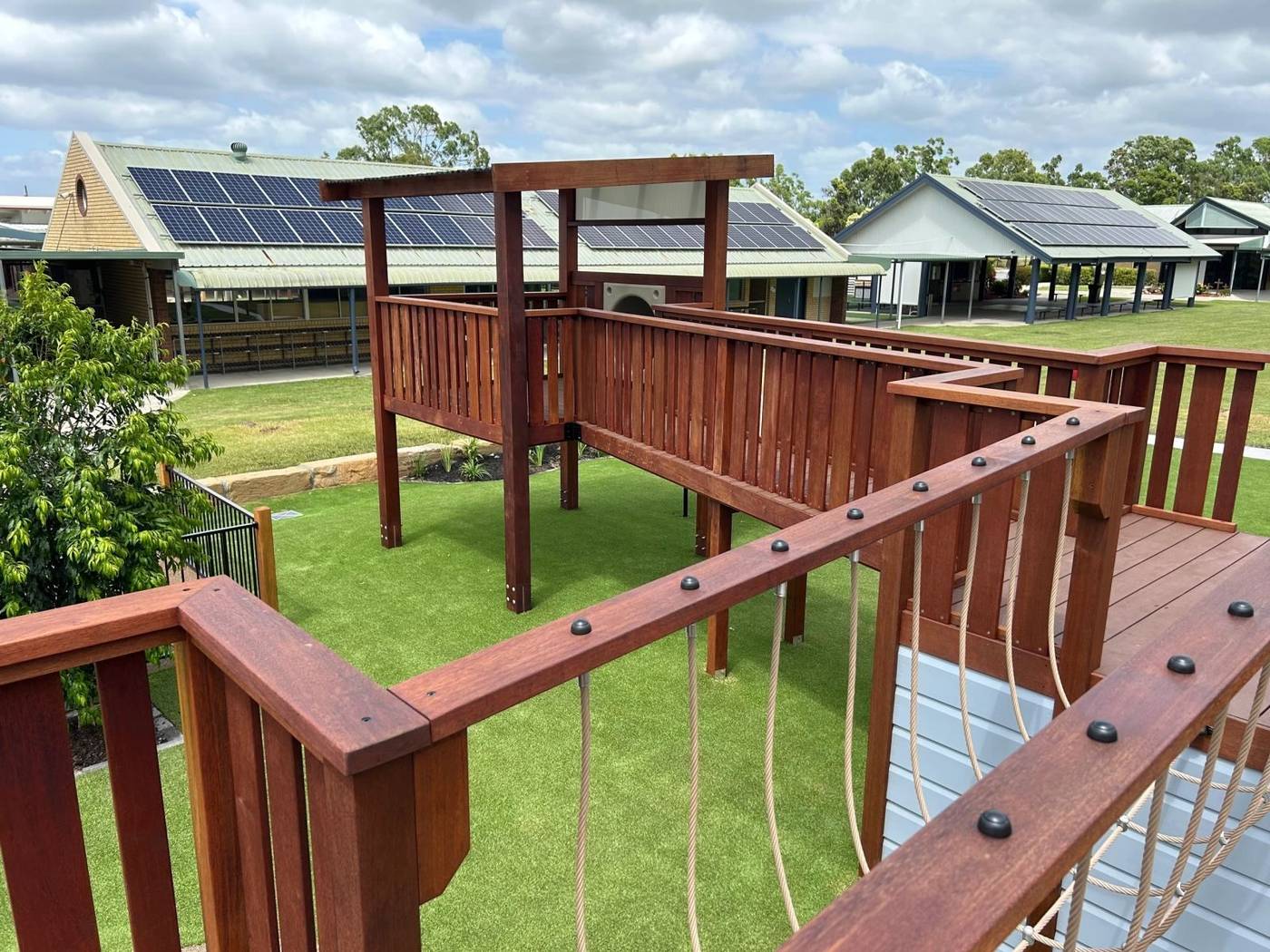 Elevated hardwood timber walkway with rope railings at a school