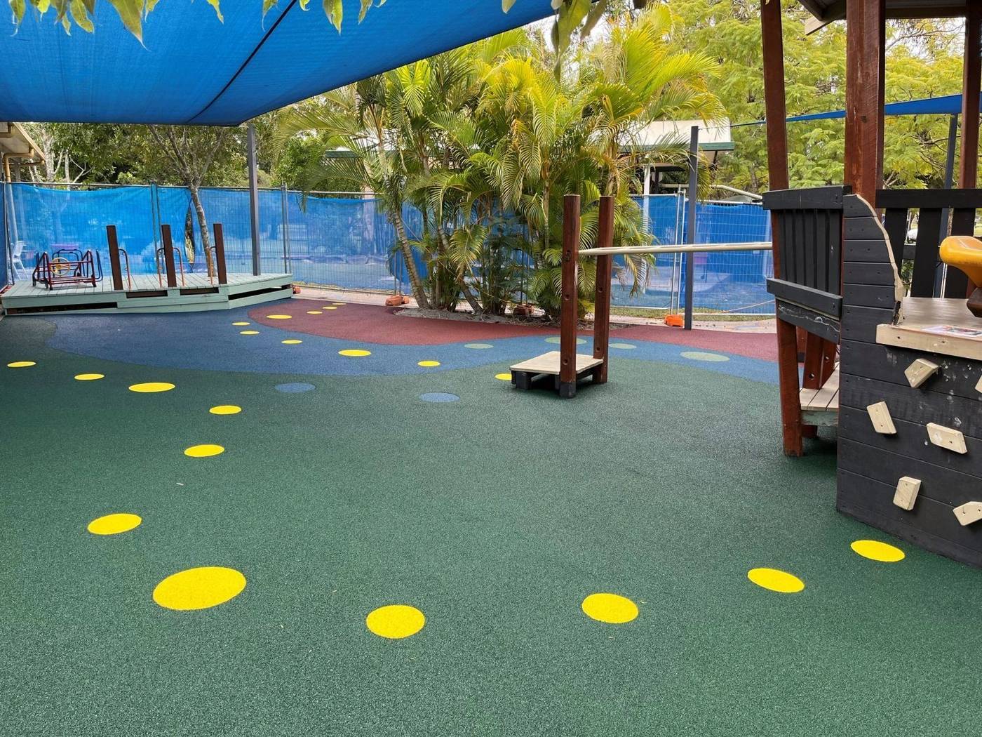 Natural timber playscape with synthetic turf